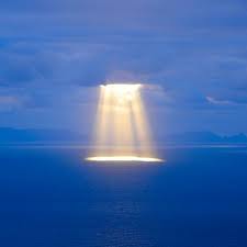Sunshine through clouds onto the sea
