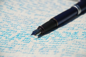 Fountain pen laying on paper with written text