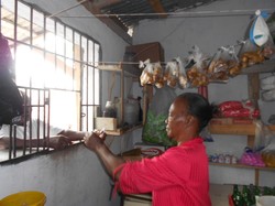 Sainte Elaine Cimus, who was helped through the Service Chretien d'Haiti program, sells items from her store.