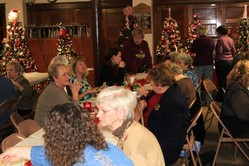 A group of people sitting at tables during a tree auction.